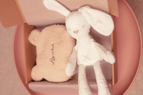 alt="Zestaw prezentowy dla niemowlaka – personalizowana kosmetyczka i pluszowa maskotka z imieniem dziecka. Idealny prezent na baby shower, chrzest lub narodziny, wyprawka z haftem."