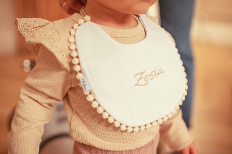 alt="Personalizowany zestaw prezentowy dla niemowlaka – kocyk i śliniaczek z imieniem dziecka. Idealny prezent na chrzest, baby shower lub narodziny, wyprawka dla noworodka z haftem."
