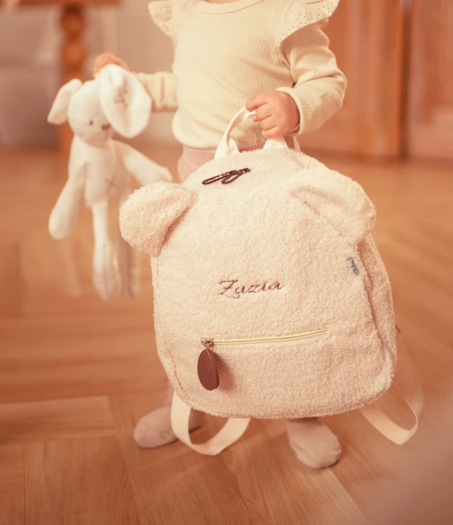 alt="Personalizowany zestaw prezentowy beżowy – plecaczek i kosmetyczka z imieniem dziecka. Idealny prezent na chrzest, baby shower lub wyprawkę dla niemowlaka i przedszkolaka."