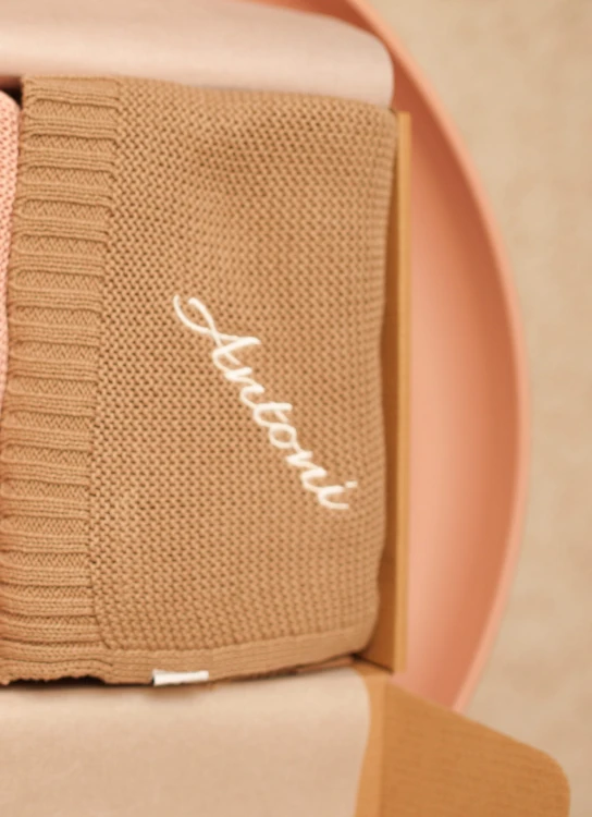 alt="Personalizowany zestaw prezentowy dla niemowlaka – kocyk i śliniaczek z imieniem dziecka. Idealny prezent na chrzest, baby shower lub narodziny, wyprawka dla noworodka z haftem."